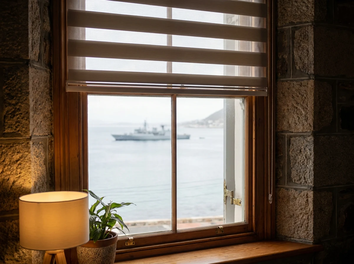 Day/night zebra blind in a Simon's Town stone cottage window with a naval vessel visible on the bay